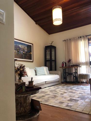 a living room with a white bed and a rug at Chalé Refidim in Gravatá