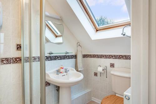 a bathroom with a sink and a toilet and a window at 4 Bed in Upton Cross oc-j34643 in Upton