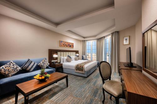 pokój hotelowy z łóżkiem i kanapą w obiekcie Braiden Hotel w mieście Al-Dżubajl