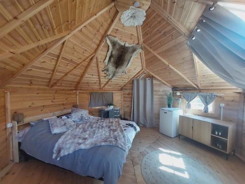 a bedroom with a large bed in a wooden ceiling at Auvergne Kota in Brugheas
