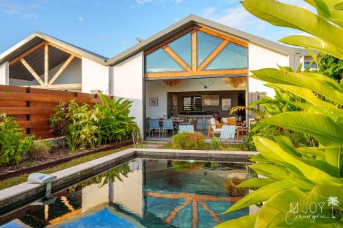 a home with a swimming pool in front of a house at VILLA ESCALE TROPICALE - classée 5 in Petite Île