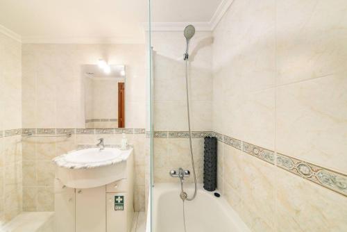 a bathroom with a shower and a sink and a tub at Ocean Gardens Apartment by Mth in Caniço
