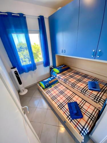 two beds in a room with blue cabinets at Seaside in San Nicola Arcella! in Saracena