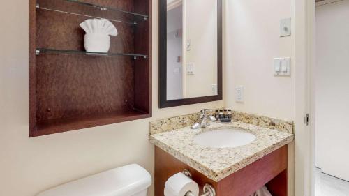 a bathroom with a sink and a toilet and a mirror at Whistler Peak Lodge in Whistler
