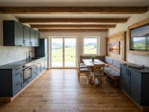 a kitchen with a table and a dining room at Panorama Suite am Marschbachhof in Walchsee
