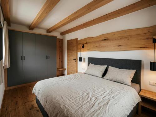 a bedroom with a large bed and wooden ceilings at Panorama Suite am Marschbachhof in Walchsee