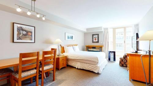 a hotel room with a bed and a desk and a desk at Whistler Peak Lodge in Whistler
