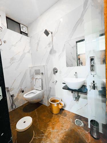 a bathroom with a toilet and a sink at Hotel G17 and Restaurant in Dhāmnod