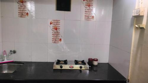a kitchen with a stove with two cats on it at Atithi homestay Solapur in Solapur
