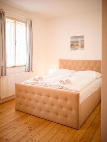 a large bed in a bedroom with a wooden floor at Dobersbergerhof in Dobersberg
