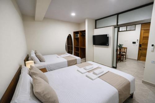 a hotel room with two beds and a television at studio confort in Iquitos