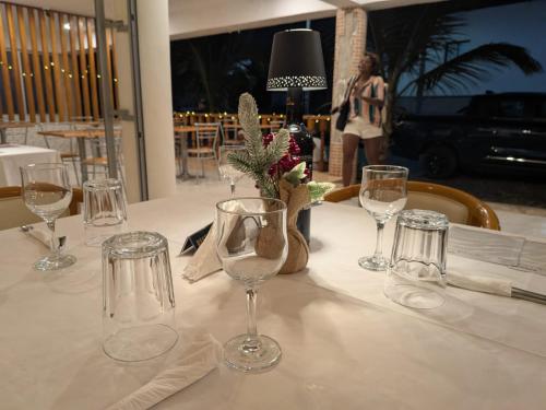a table with wine glasses on a white table cloth at Hotel Strela Tarrafal in Tarrafal