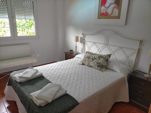ein Schlafzimmer mit einem weißen Bett, auf dem zwei Handtücher liegen in der Unterkunft Chalet Kuki in Ribas