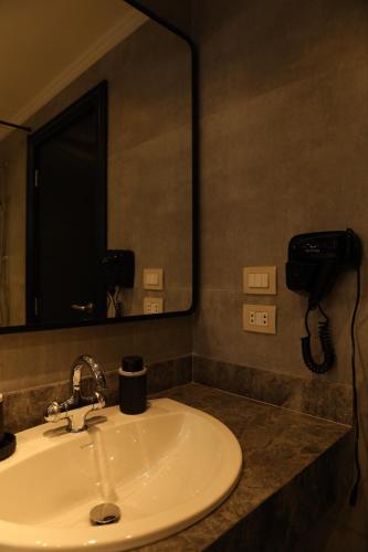 un lavandino del bagno con uno specchio e un telefono di Munir’s residence a Il Cairo