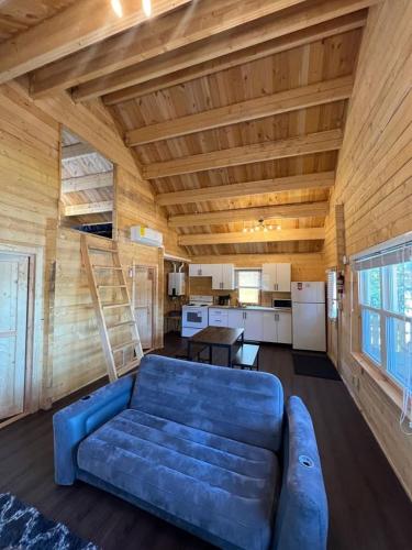 a living room with a blue couch and a kitchen at Horseshoe Lake Beachside Cottage in Parry Sound