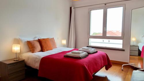 a bedroom with a bed with a red blanket and a window at FLH Funchal Modern Apartment with Pool in Funchal
