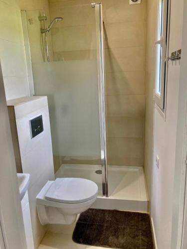 a white bathroom with a toilet and a shower at Cisy Resort-idealny dla gości ze zwięrzętami,ogrodzony teren na wyłączność,150 m od jeziora in Makosieje