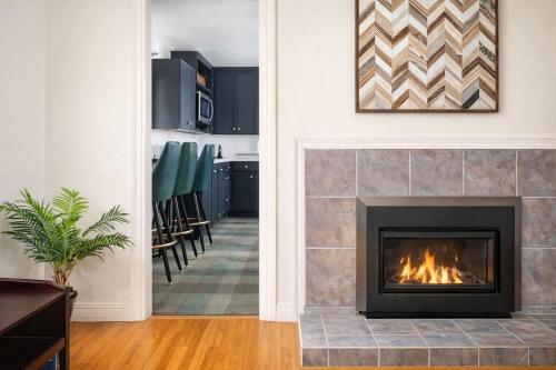 a living room with a fireplace and a kitchen at Private Riverside Retreat in Appleton