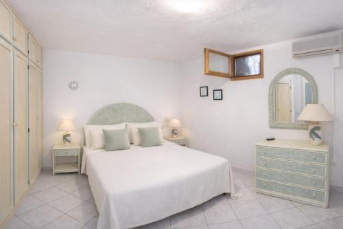 a white bedroom with a bed and two night stands at Sardinia Re - Grecale 25 in Porto Rotondo