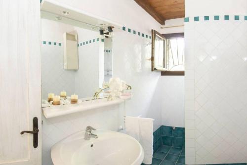 a white bathroom with a sink and a mirror at Sardinia Re - Grecale 25 in Porto Rotondo