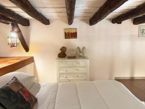 a bedroom with a white bed and a dresser at Camidù Boutique House in Palermo