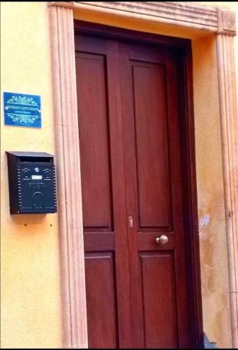 a wooden door with a sign on the side of a building at Acchianata Santo Spirito in Agrigento