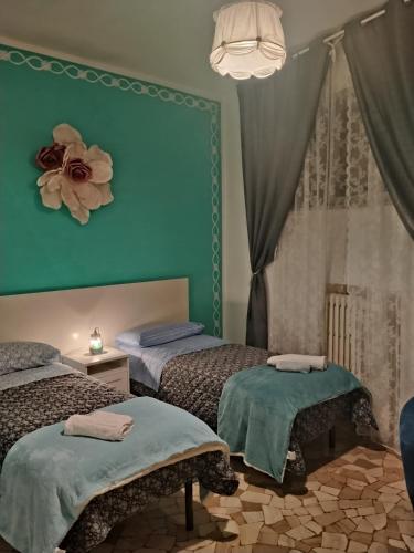 a bedroom with two beds and a flower on the wall at Casa di Ana 2 affittacamere in Ancona