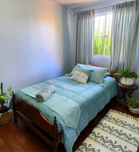 a bedroom with a bed with blue sheets and a window at Casa Runa in Quillota