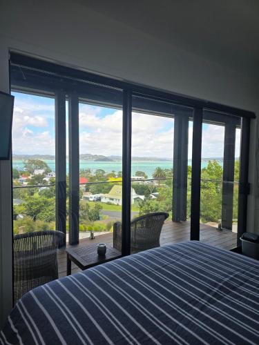 a bedroom with a bed and a view of the ocean at Studio with amazing views in Russell