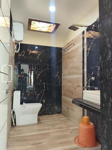 a bathroom with a black wall and a sink and a toilet at Aryans Sea Sight Resort Mandarmani in Mandarmoni