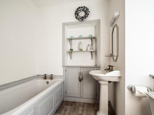 a bathroom with a tub and a sink at The Old Library, Brora in Brora