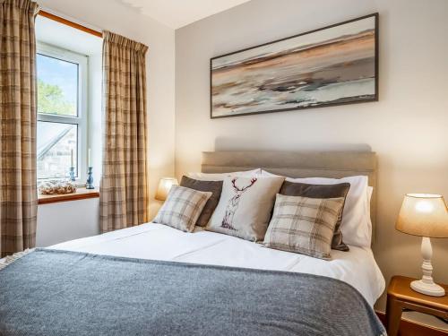 a bedroom with a bed and a window at The Old Library, Brora in Brora