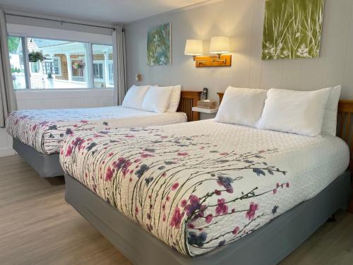 a bedroom with two beds and a window at Kennebunkport Motor Lodge in Kennebunkport