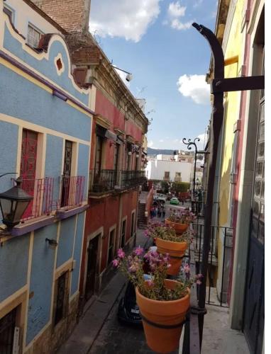 a row of flower pots on the side of buildings at Canteira Boutique ApartHotel in Guanajuato