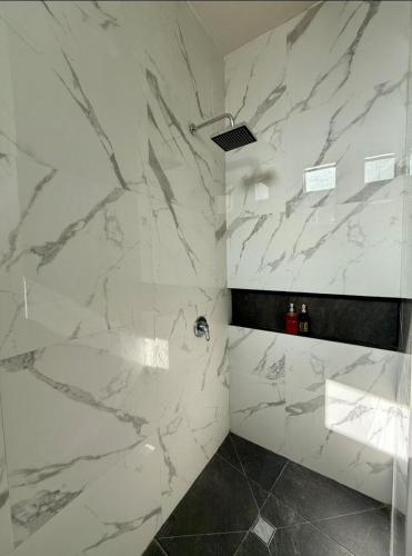 a bathroom with white marble walls and a shower at Canteira Boutique Aparthotel in Guanajuato