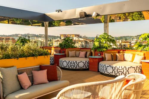 a balcony with two beds and chairs on a roof at The Social Hub Florence Belfiore in Florence