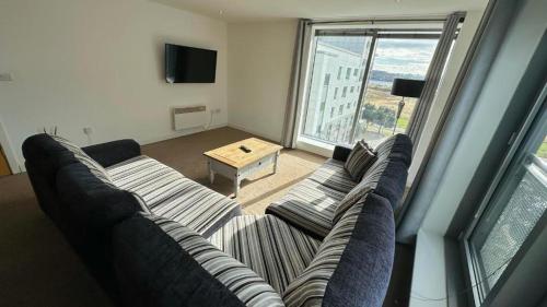 a living room with a couch and a table at Britannia Apartments in Edinburgh