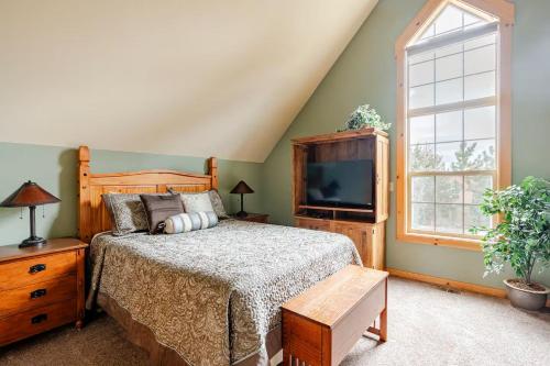 a bedroom with a bed and a tv and a window at 19th Hole Chalet at Eagle Crest in Redmond