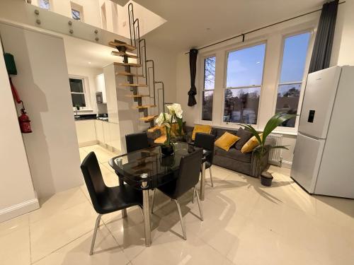 a living room with a glass table and black chairs at Private Luxury Ensuite Room Greater London, Free Parking Gatwick 15MIN in Croydon