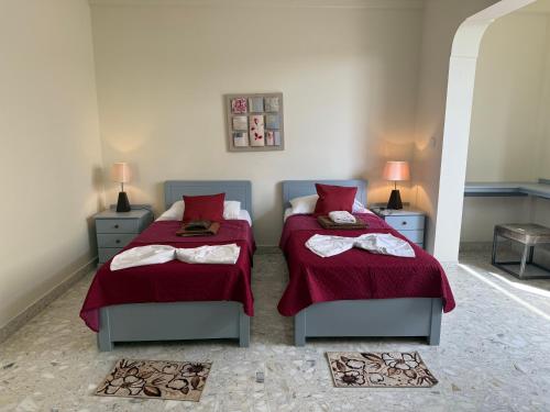 a bedroom with two beds with red sheets and towels at Panoramic XL Penthouse Sliema Seafront in Sliema