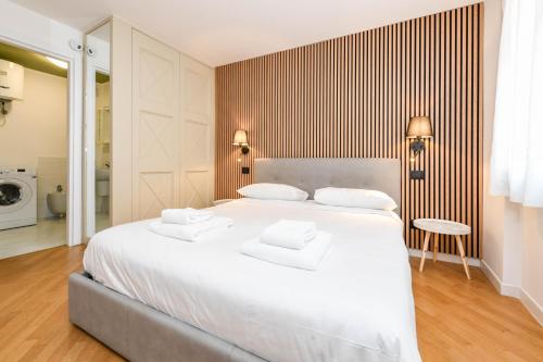 a bedroom with a large white bed with two pillows at NEW Appartamenti Anna in Sirmione