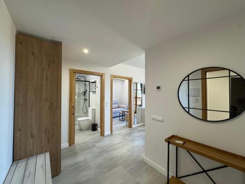 a living room with a mirror and a bathroom at Hotel Lupus Silva in Villardeciervos