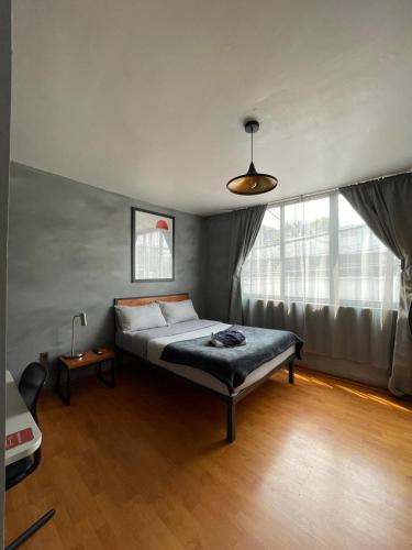 a bedroom with a bed and a large window at Compact Studio Apartment Casa Icacos Apt 4 in Mexico City