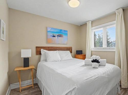 a bedroom with a white bed and a window at Executive-BBQ-Full-Kitchen-Washer-Dryer-Sauna-Backyard-Parking-Air-Conditioning in Blue Mountains
