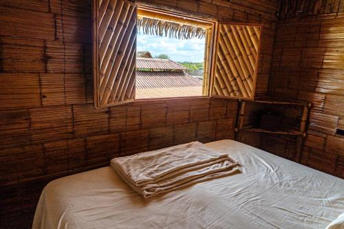 a small room with a bed with a window at Estados Unidos Experience in Ríohacha