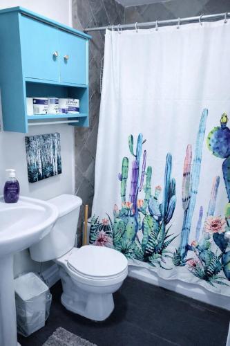 a bathroom with a cactus shower curtain and a toilet at Executive-BBQ-Full-Kitchen-Washer-Dryer-Sauna-Backyard-Parking-Air-Conditioning in Blue Mountains