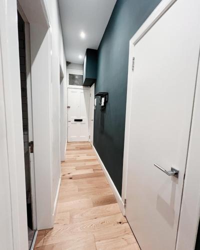 a hallway with a white door and a green wall at Central Leith Suite in Edinburgh