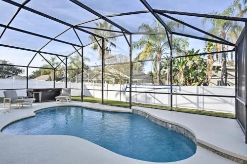 a swimming pool in a glass house with a patio at Luxury Retreat with 2 Master Suites Pool & Hot Tub BBQ Pool Table 2 Miles Disney in Orlando