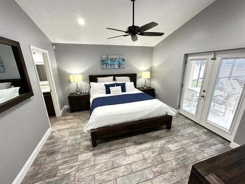a bedroom with a bed and a ceiling fan at Luxury Retreat with 2 Master Suites Pool & Hot Tub BBQ Pool Table 2 Miles Disney in Orlando