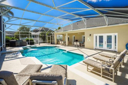 a swimming pool with chairs and a house at Phenomenal 7BR 4 Master Suites Southeast Pool Hot Tub Gas BBQ 2 Miles to Disney in Orlando